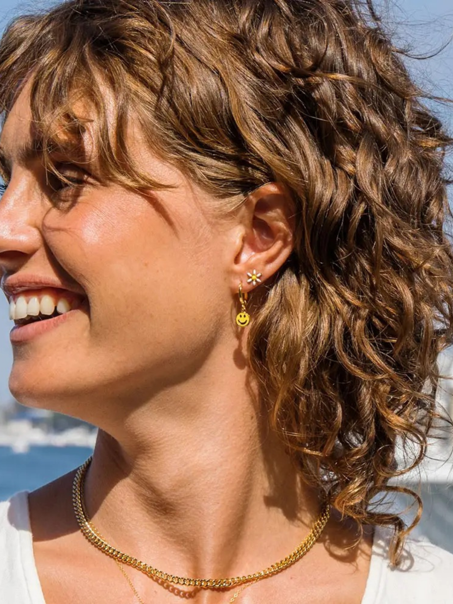 A pair of delicate Daisy Earrings by Amano Studios with floral design, showcasing silver-tone metal and intricate petal details.