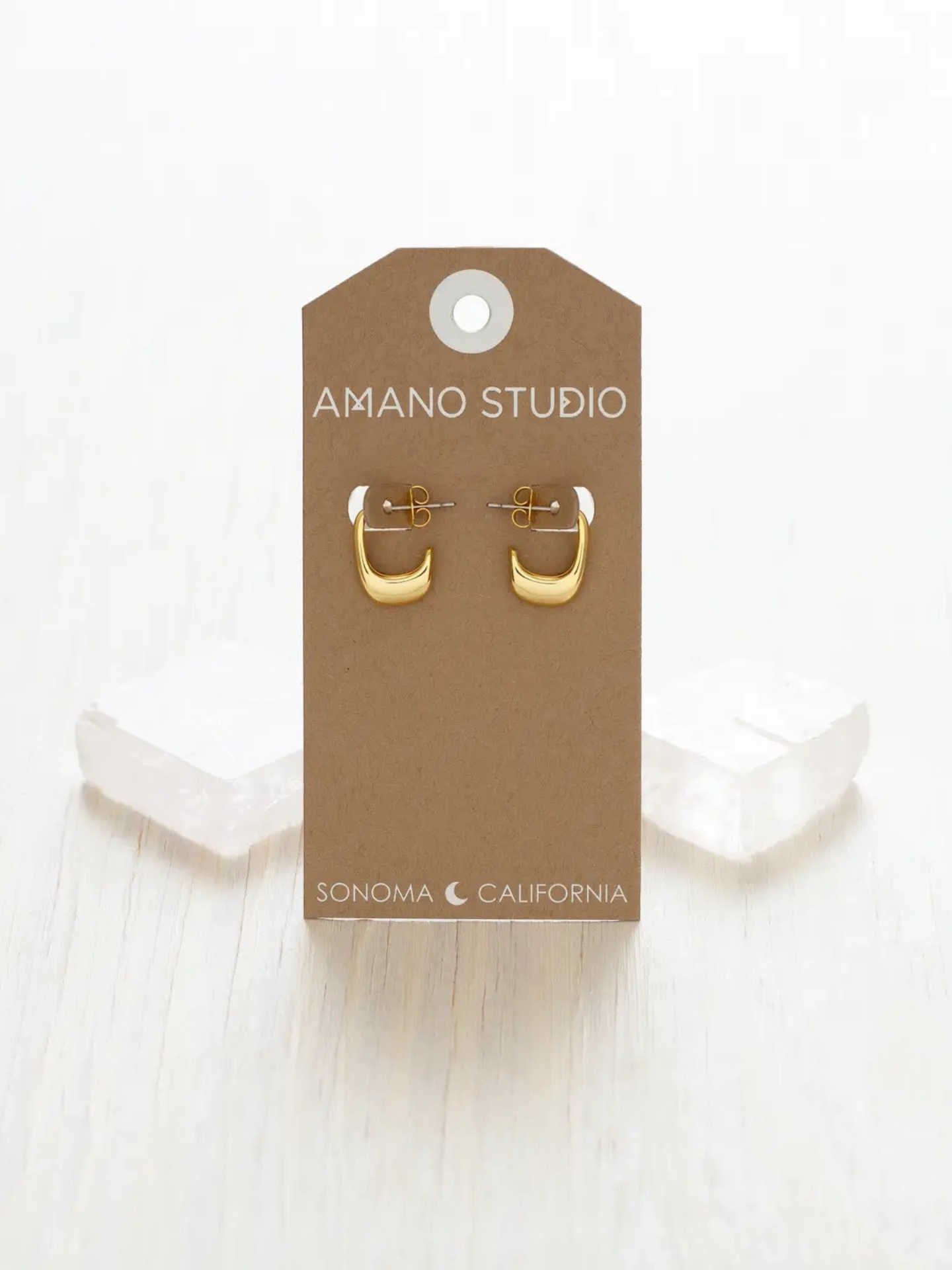A pair of delicate rose-shaped earrings by Amano Studios featuring detailed metalwork and floral design.