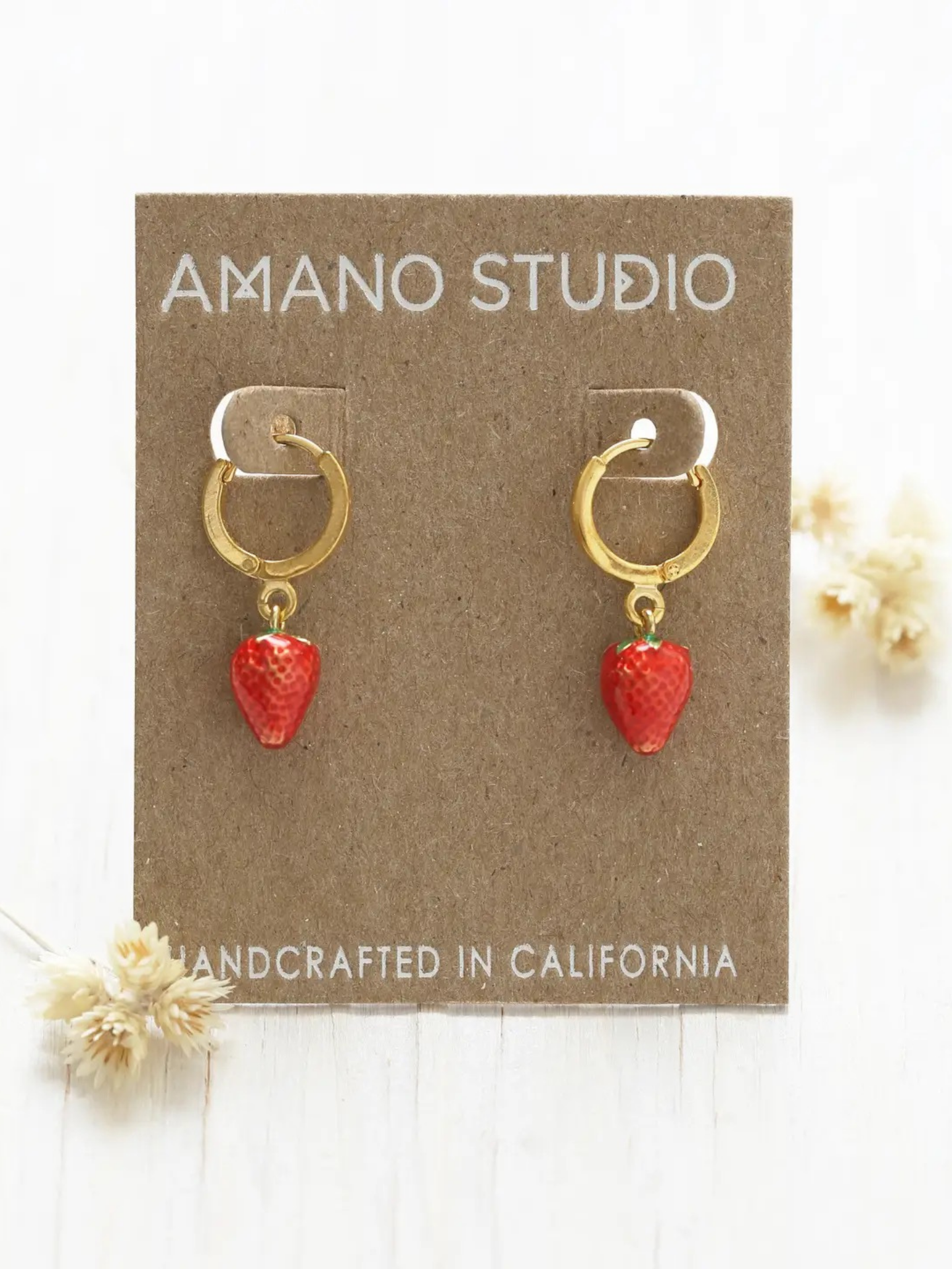 A pair of berry-shaped earrings with vibrant red and green accents by Amano Studios, designed as stylish jewelry accessories.