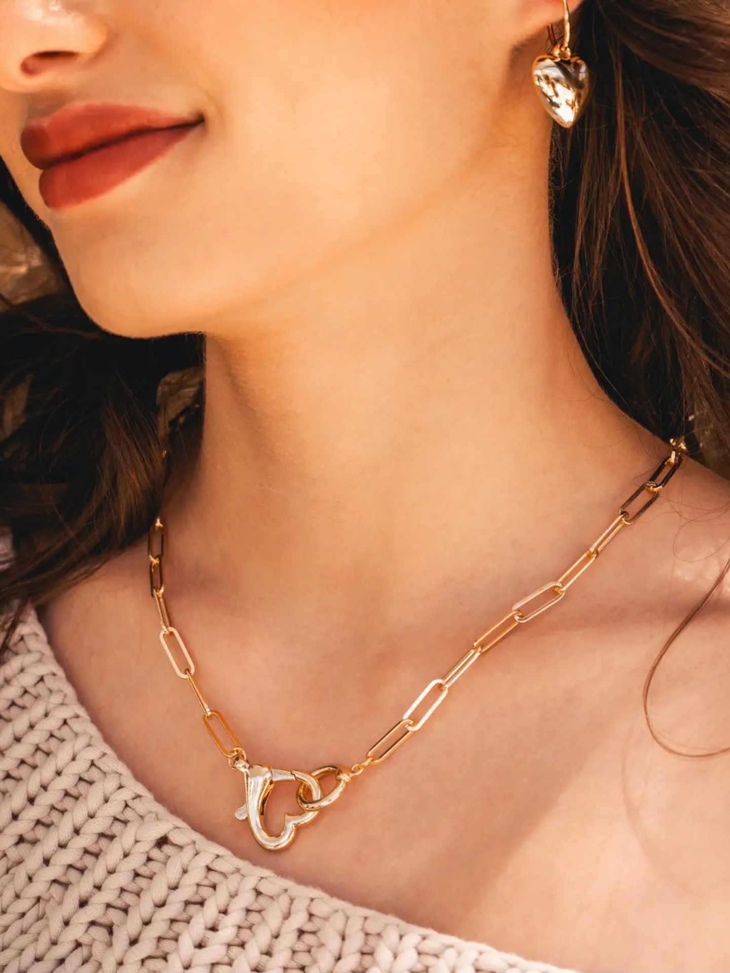 Amano Studios heart necklace featuring a delicate chain and a heart-shaped pendant on a plain background.