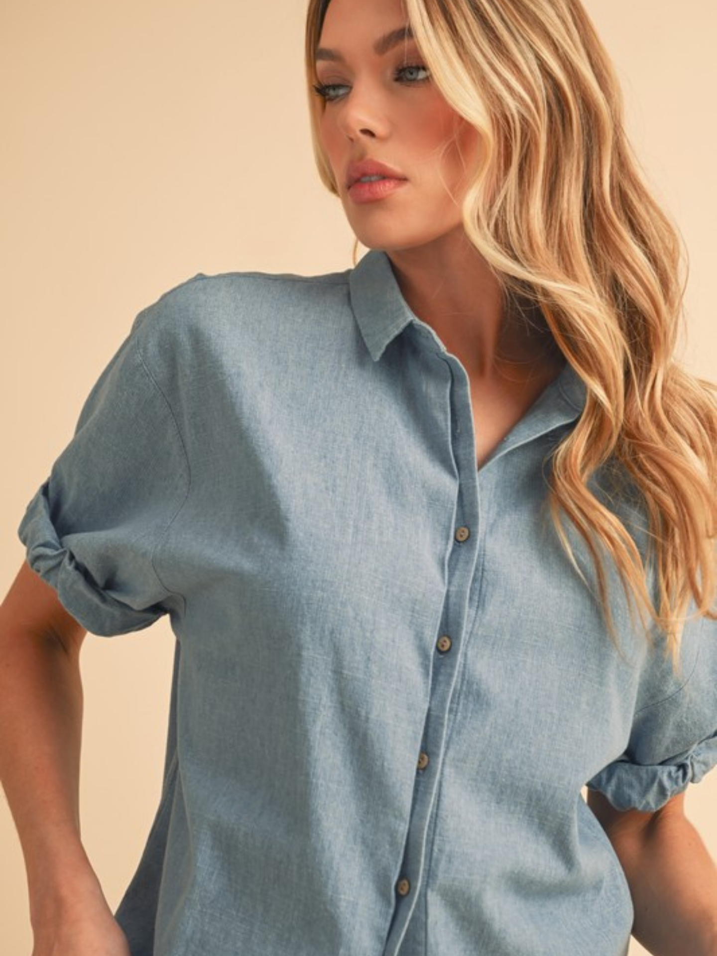 Ariemi + Co blue denim button-up shirt, casual apparel with front buttons and long sleeves, displayed on a plain background.