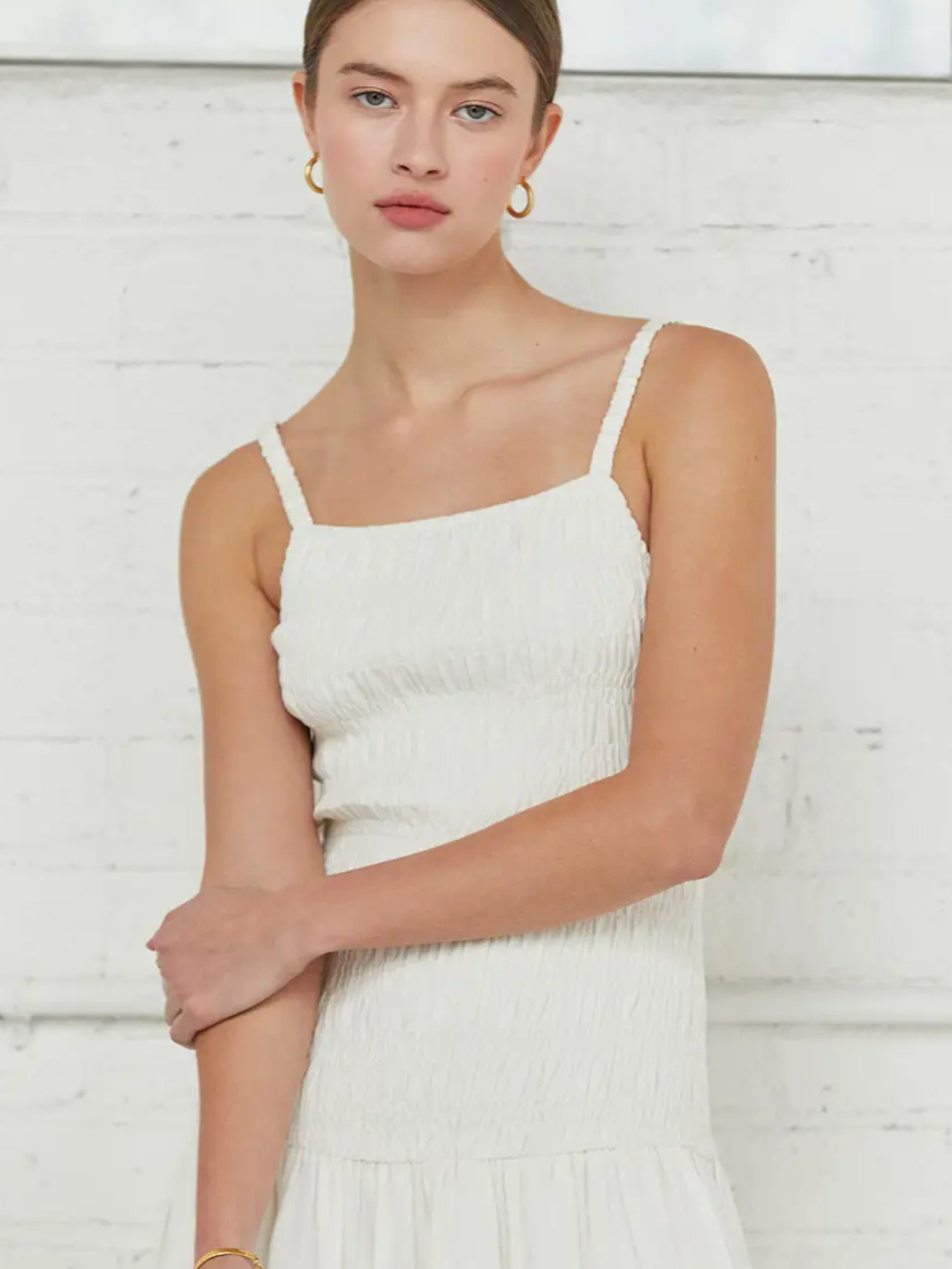 White Crescent smocked body dress showing fitted bodice, short sleeves, and knee-length skirt on a model.